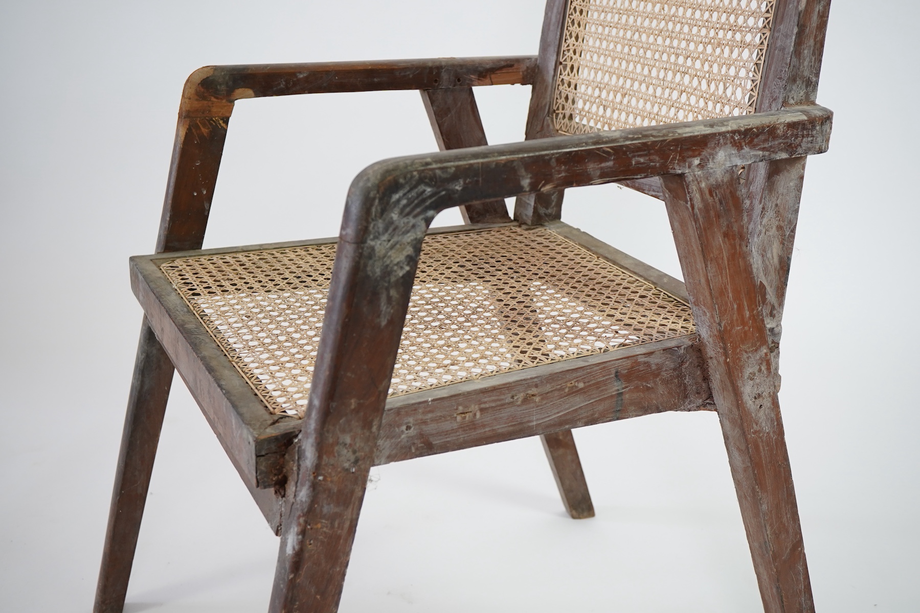 Manner of Pierre Jeanneret (Swiss, 1896-1967): A solid teak and braided canework armchair